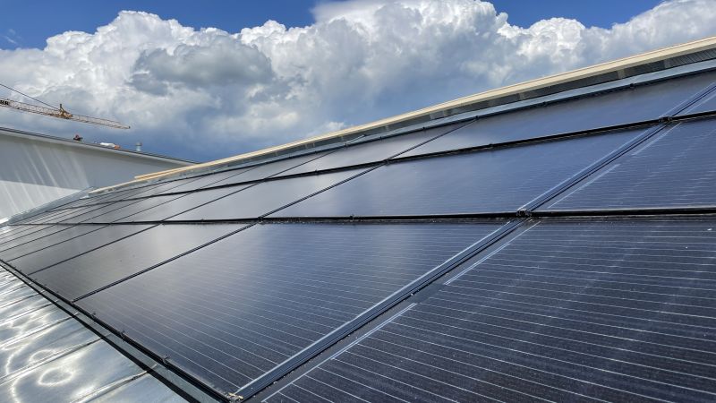 Nahaufnahme einer Solrif-Indachfläche mit schwarzen Glas-Glas-Modulen vor bewölktem Himmel, Murnau